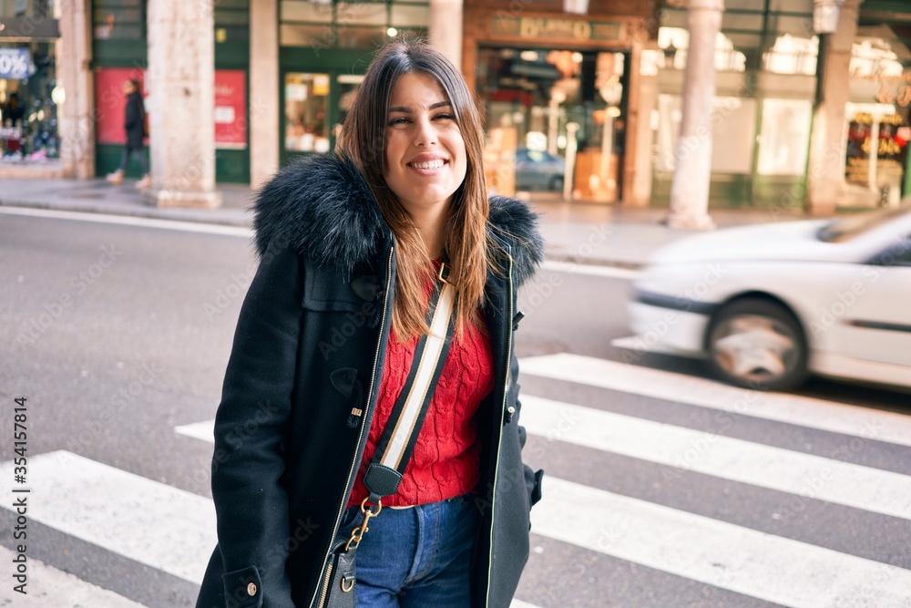 Young beautiful brunette woman smiling happy and confident. Standing with smile on face walking at street of city