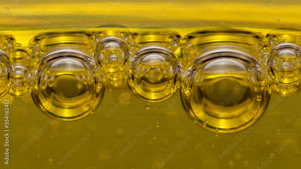 air balls, of different sizes, in a yellow, viscous liquid, tend to the surface, macro shot