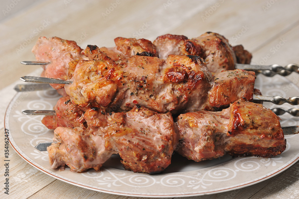 pork skewers on skewers in a plate on a wooden background
