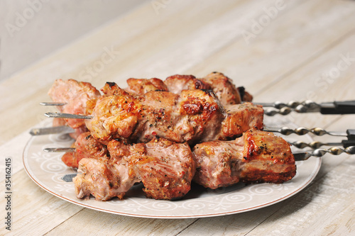 pork skewers on skewers in a plate on a wooden background