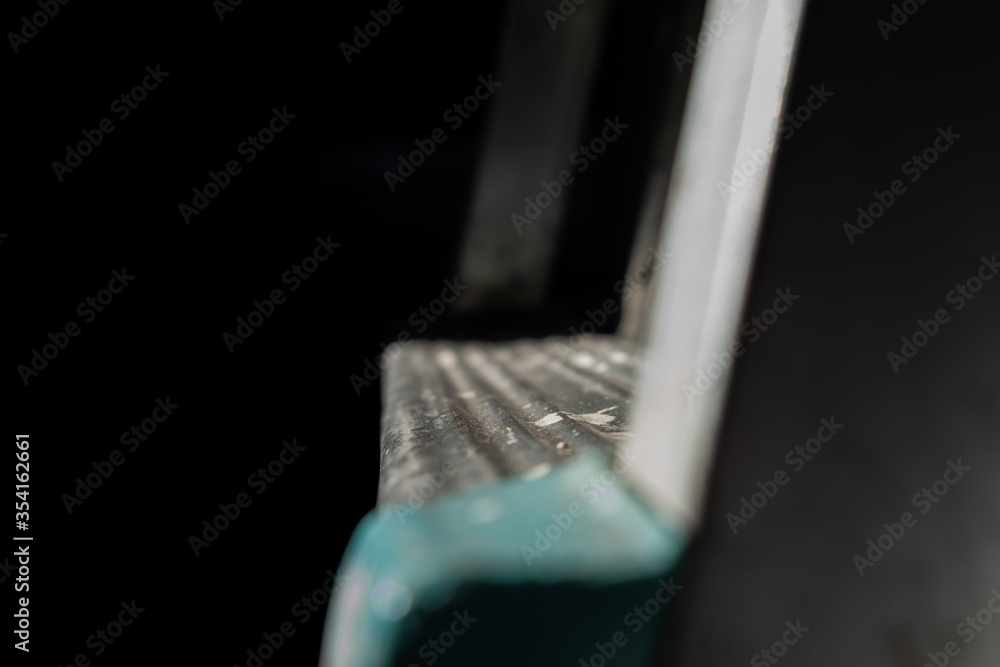 Close up of daylight illuminate step of steel portable or mobile ladder on the roof Close up of daylight illuminate step of steel portable or mobile ladder on the roof