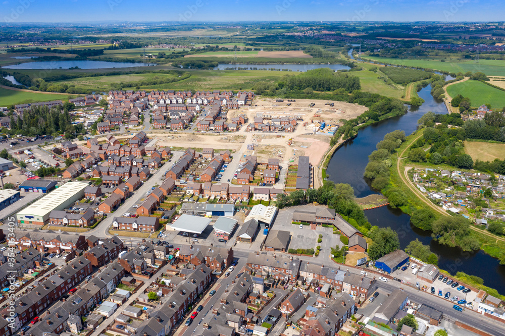 Aerial photo of the village centre of Castleford in Wakefield, West Yorkshire, England showing a new hosing estate being built along side the River Aire on a bright sunny summers day