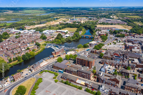 Fototapeta Naklejka Na Ścianę i Meble -  Aerial photo of the village centre of Castleford in Wakefield, West Yorkshire, England showing the main street along side the River Aire on a bright sunny summers day