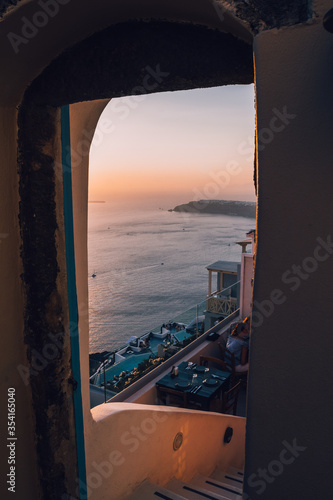 View of the caldera of Santorini through a gate of a restaurant at the top of Oia