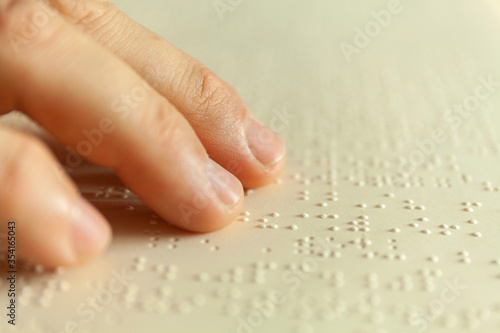 Braille reading. Blind man reads a book in braille