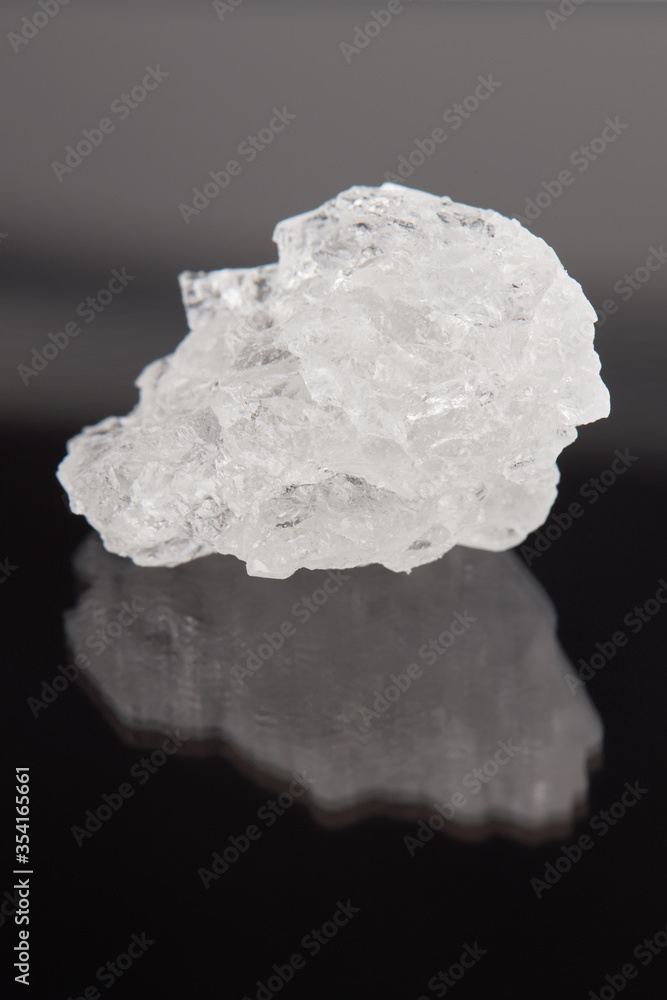 rock salt crystal over dark background. outer space. vertical orientation. rock salt crystal over dark background. outer space. vertical orientation.