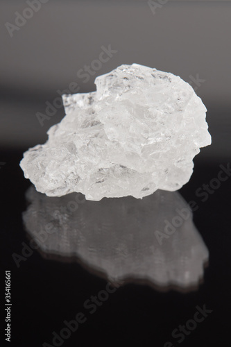 rock salt crystal over dark background. outer space. vertical orientation.