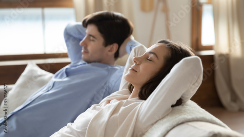 Fotografía Calm young caucasian couple relax on comfortable couch at home taking nap or sle