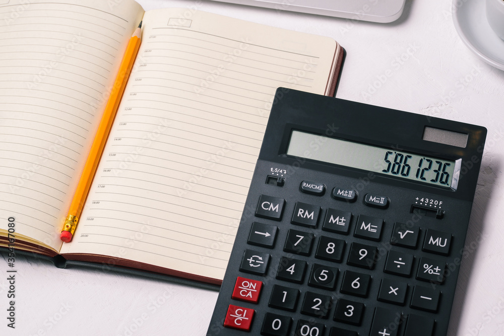 Open diary, pencil and calculator. Desktop of a company employee or businessman. Top view, copy space. Open diary, pencil and calculator. Desktop of a company employee or businessman. Top view, copy space.