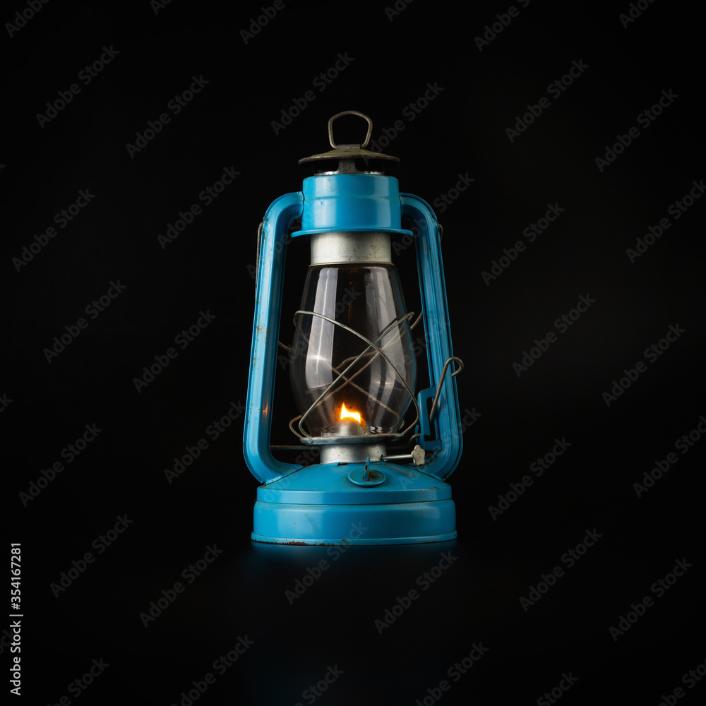 Blue vintage kerosene lantern isolated on abstract black background - obrazy, fototapety, plakaty 