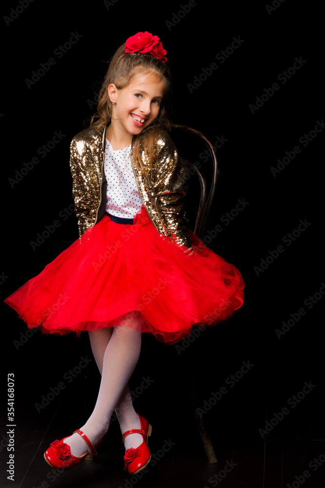 Portrait of a little girl sitting on an old Viennese chair, black background. Portrait of a little girl sitting on an old Viennese chair, black background.