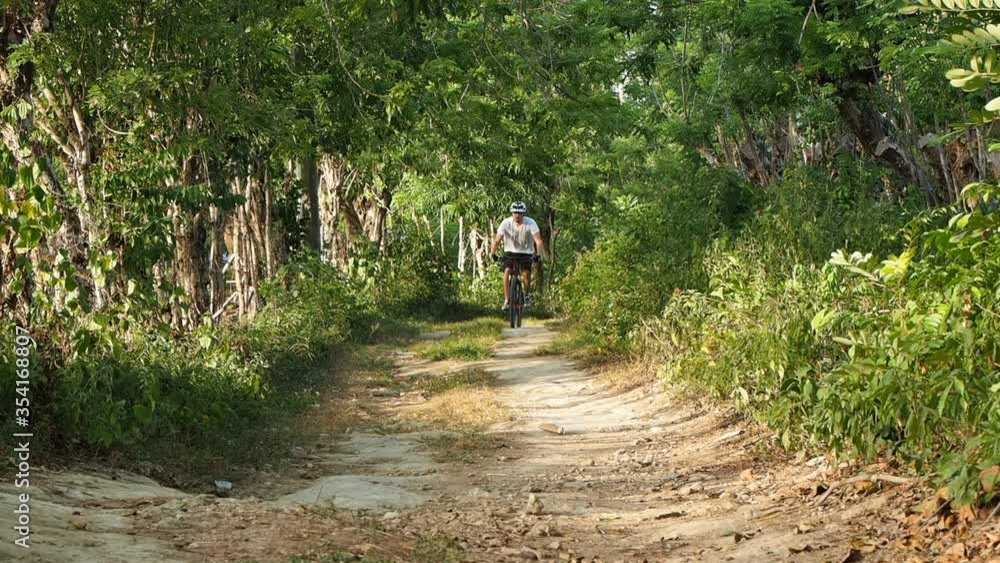 Bicyclist is riding on mountain bike on trail. Bicyclist is riding on mountain bike on trail.