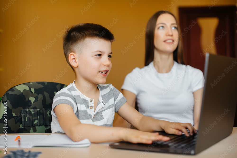 A mother and her child are engaged in distance learning at home in front of the computer. Stay at home, training A mother and her child are engaged in distance learning at home in front of the computer. Stay at home, training