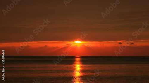 rich red sea sunset with light reflection in the water