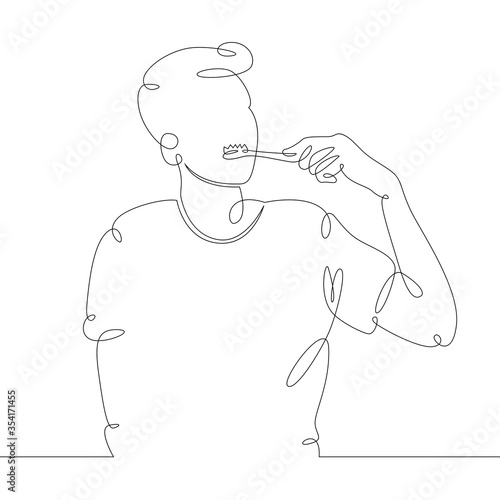 young man brushes his teeth early in the morning