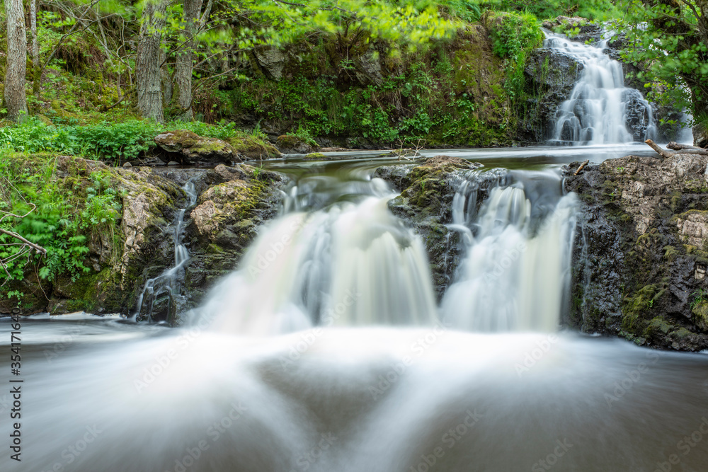 Stunning Slow falling Water Hallamolla Waterfall in lush rural Forest during springtime in Skane Osterlen near national park Stenshuvud, South Sweden.  Long Exposure Waterfall.