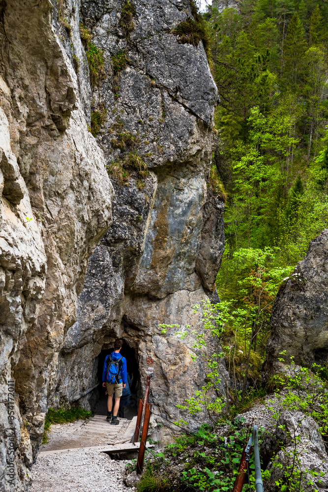 Man On Hiking Trail Enters A Cave In Ötschergräben In Austria