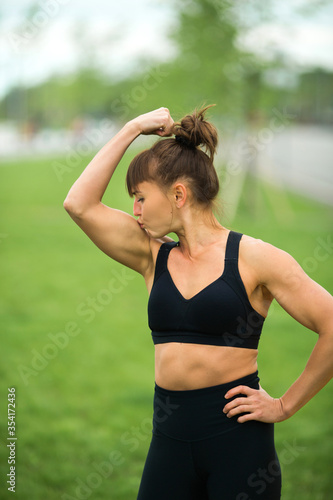 beautiful adult woman in sportswear in the summer in the park