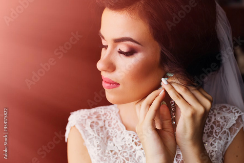 close up of beautiful woman with makeup wearing jewelry earrings