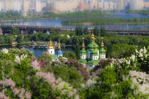 Tilt Shift Photography Blooming lilac on the background of the Vydubytsky Monastery and the Dnieper River in Kiev. Spring.