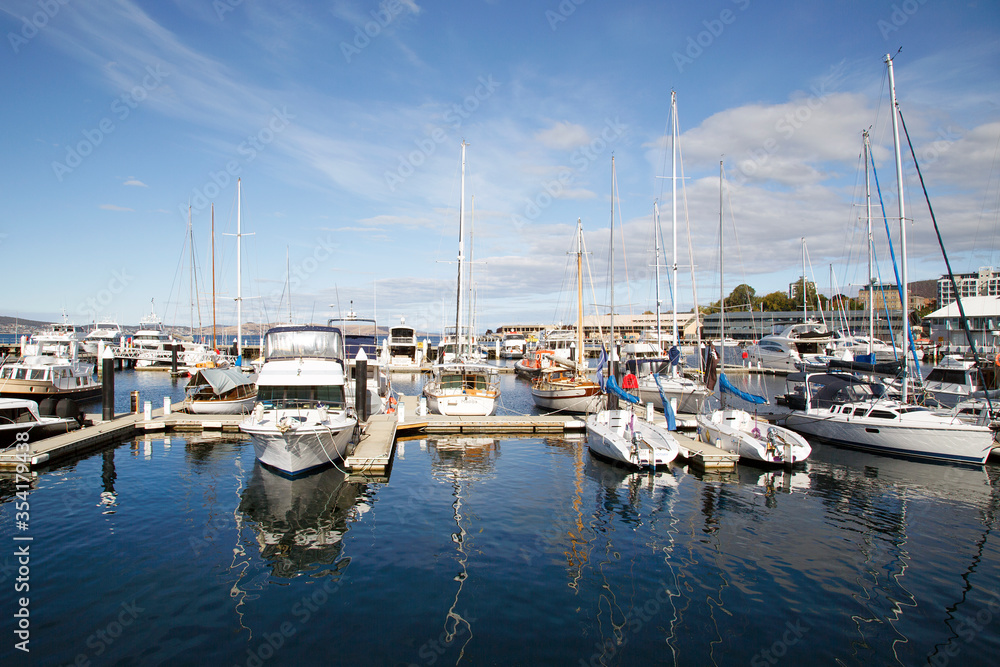 Yachts moored in Hobart Marina on a blue sky day.