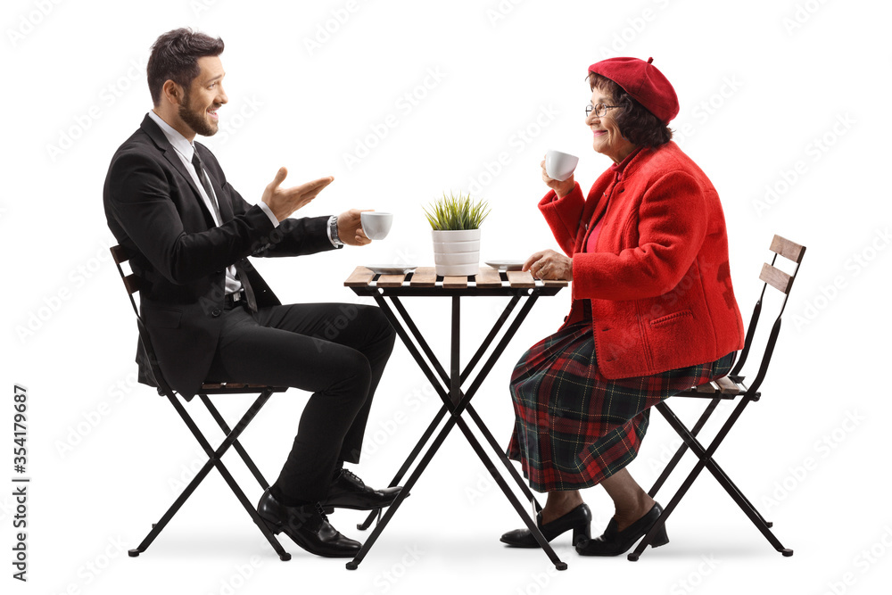 Fototapeta premium Young man in a suit sitting in a cafe with an elderly woman and talking