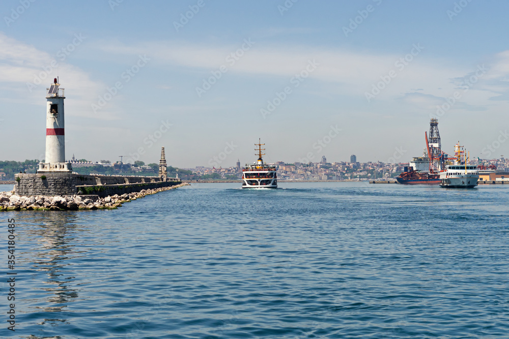 Ferry boat passing asian to european part of Istanbul. Container dock on right side. panorama of Istanbul at background
