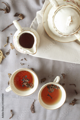 Two cup of tea with teapot, on gray background. Antique cup and teapot, 