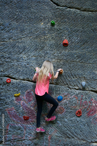 Fototapeta Naklejka Na Ścianę i Meble -  Child Girl having fun during rock climbing training on boulder wall