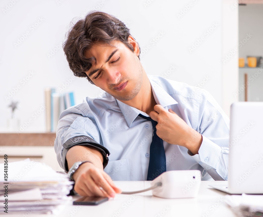 Man under stress measuring his blood pressure Man under stress measuring his blood pressure