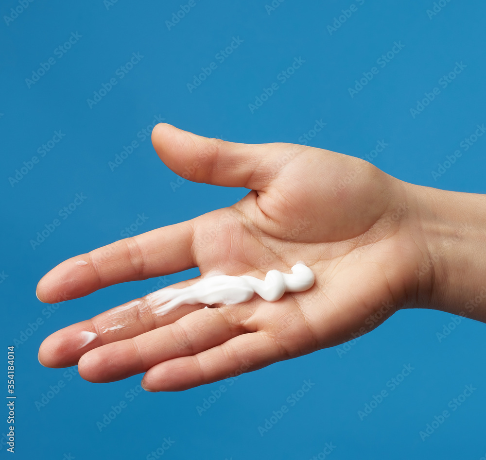on a female palm a strip of white thick moisturizer