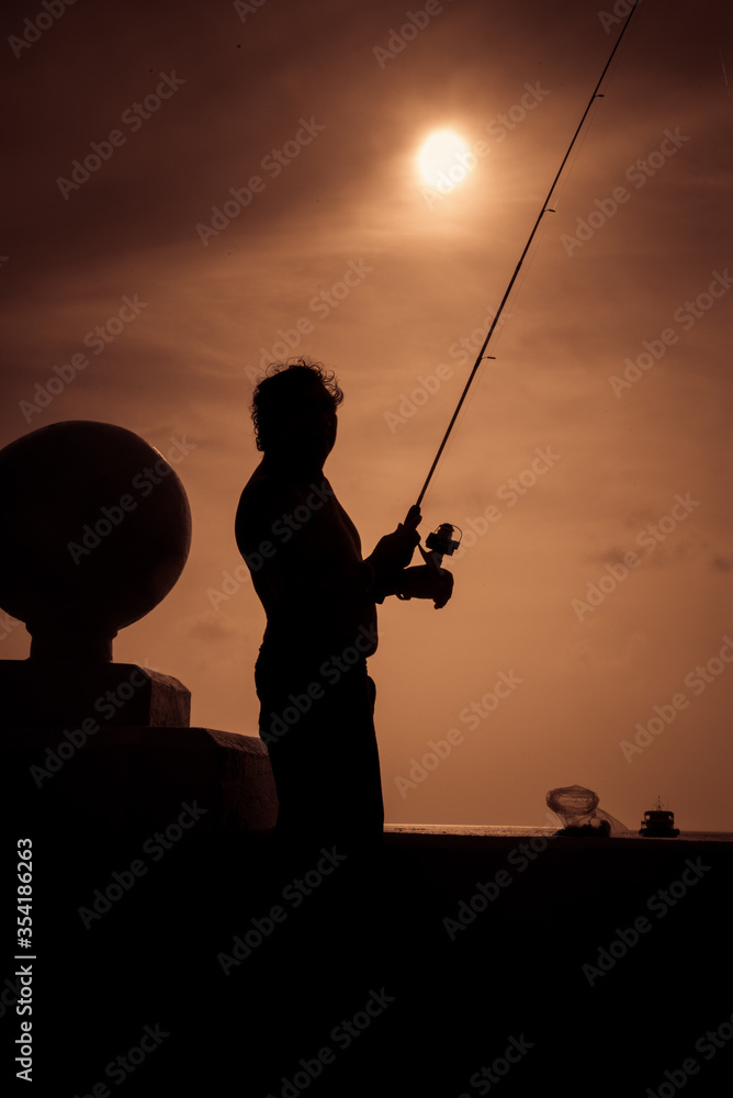 Man Fishing silhouette on a sunset, Cozumel Mexico