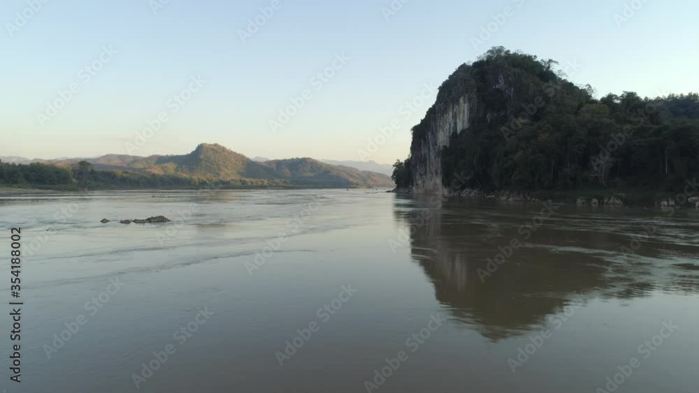 Aerial: Scenic view of river and mountains against clear sky, drone moving forward over water - Mekong River, Laos Aerial: Scenic view of river and mountains against clear sky, drone moving forward over water - Mekong River, Laos