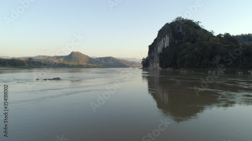 Aerial: Scenic view of river and mountains against clear sky, drone moving forward over water - Mekong River, Laos photo