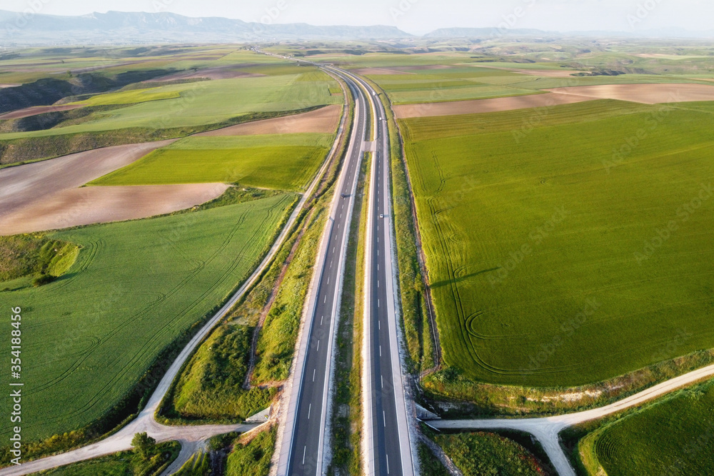 Aerial view of a highway with cars and trucks, in a beautiful countryside scenery . Aerial view of a highway with cars and trucks, in a beautiful countryside scenery .