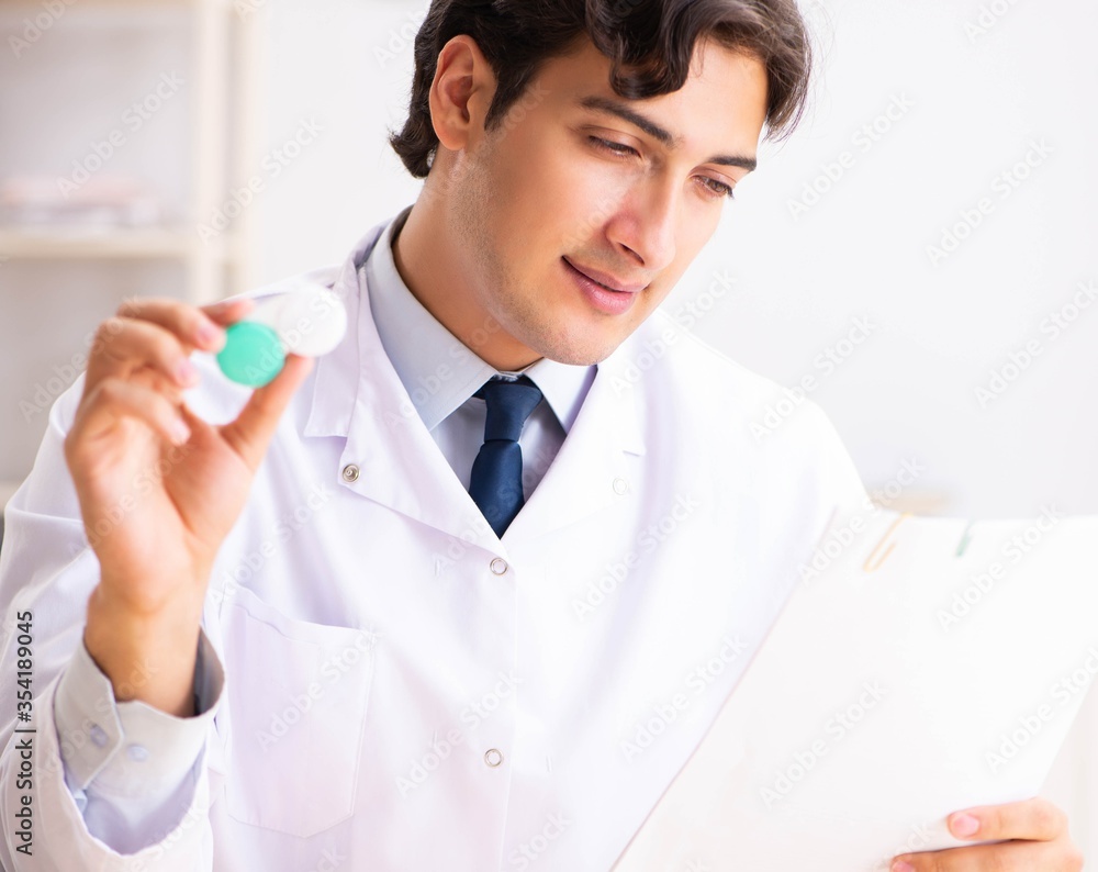 Young handsome doctor oculist working at the clinic Young handsome doctor oculist working at the clinic