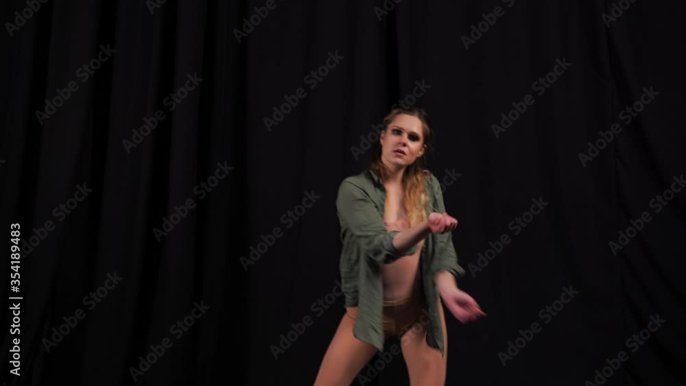 Circus artist dancing choreography on a black background. Sensual european girl performer. young girl dancing contemporary and modern choreography Circus artist dancing choreography on a black background. Sensual european girl performer. young girl dancing contemporary and modern choreography