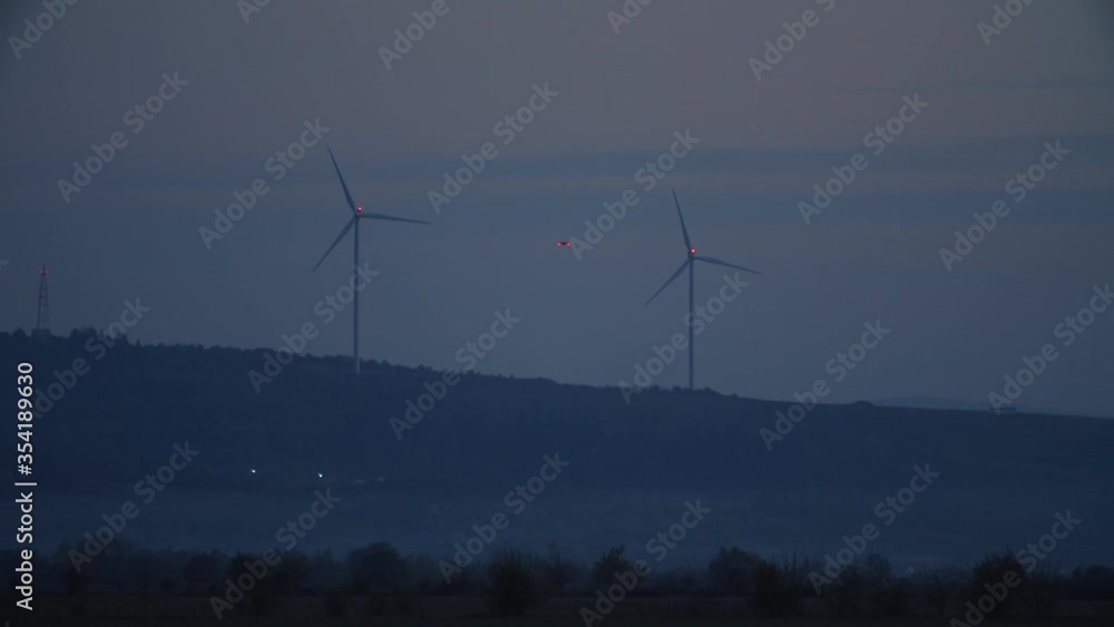 Wind farm. Drone quadcopter flying around wind station landscape monitoring condition egergy generation system in farmland at night. Smart technology concept. Wind farm. Drone quadcopter flying around wind station landscape monitoring condition egergy generation system in farmland at night. Smart technology concept.