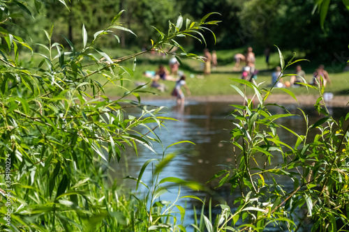 Wild swimming: Children (out of focus) swimming in nature, in the River Chess at Chorleywood, Hertfordshire UK. Swimming oudoors in natural habitats is allowed during the coronavirus lockdown. photo