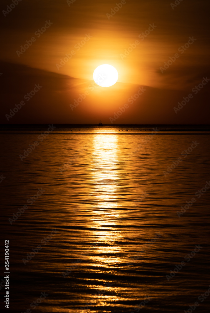 Golden sunset with reflection over the sea.