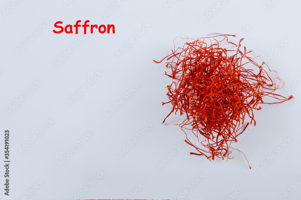 Naklejka premium Saffron threads on a white background with the inscription Saffron. Copy space.