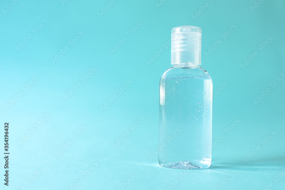 Transparent alcohol bottle is a device to prevent and stop the corona virus. on blue isolated backgroun Transparent alcohol bottle is a device to prevent and stop the corona virus. on blue isolated backgroun