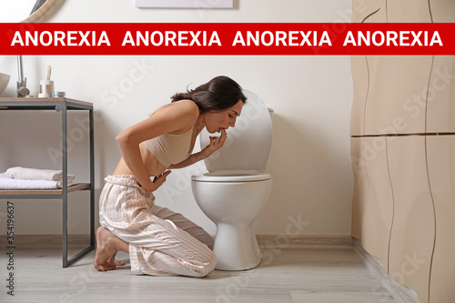 Vomiting young woman near t...