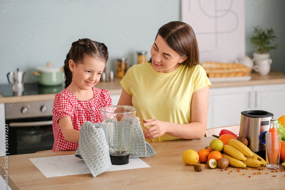 Mother and little daughter cleaning blender in kitchen Mother and little daughter cleaning blender in kitchen