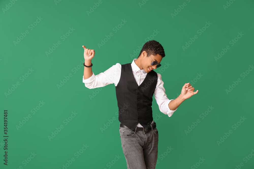 African-American teenager dancing against color background African-American teenager dancing against color background