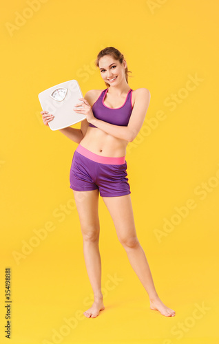 Young woman with weight sca...