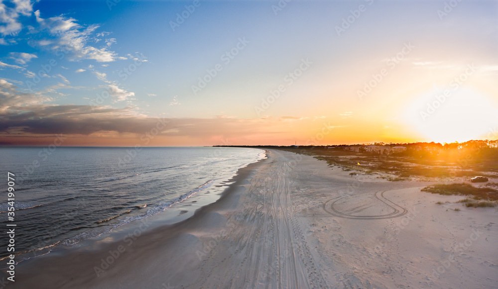 Aerial landscape of an ocean and beach at sunset