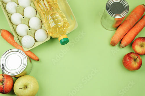 Various food products lay on green background. Purchase of products, delivery or donation,stock of products on shelves for quarantine and blocking period.Long-term food supplies.Top view,free space.