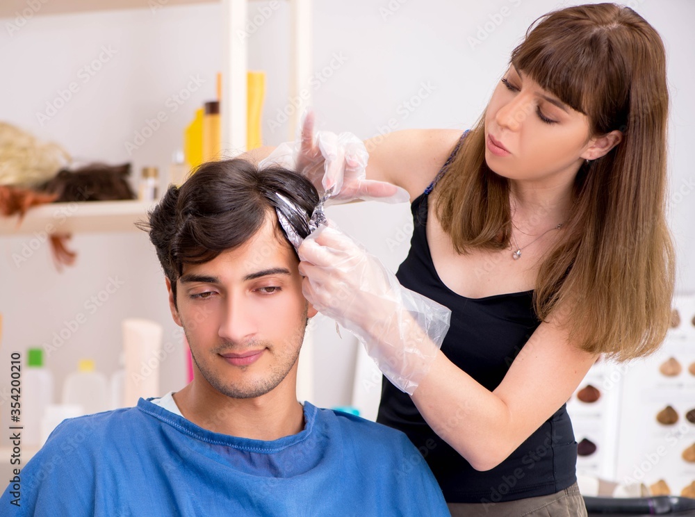 Young attracrive man visiting female barber Young attracrive man visiting female barber