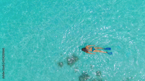 TOP DOWN: Unrecognizable female tourist snorkels around the turquoise ocean